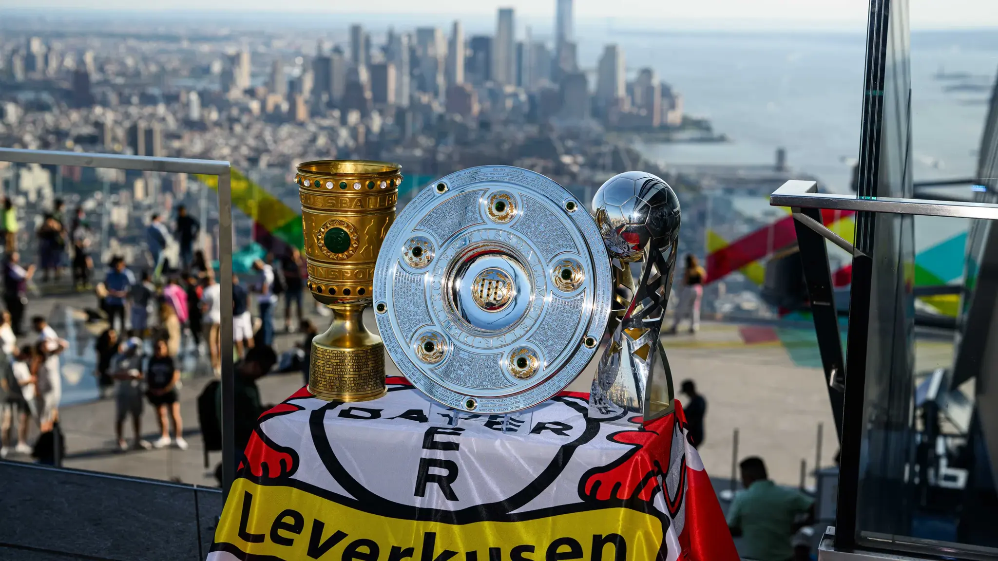 A picture of the trophies with the New York skyline in daylight in the background